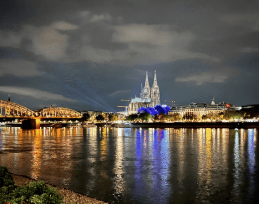 Abendstimmung in Köln mit Rhein, Dom und beleuchteter Hohenzollernbrücke