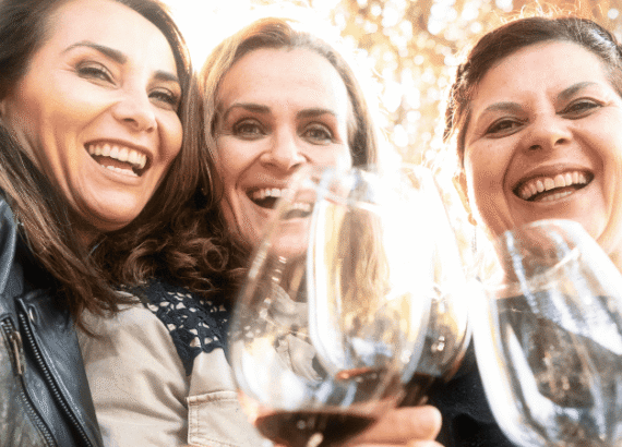 freundinnen lachen und halten weinglaeser unternehmungen koeln freunde