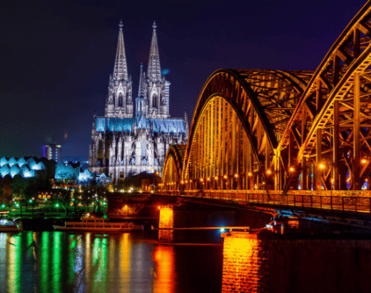 Beliebte Shops in der Kölner Innenstadt in Abendstimmung mit Dom und Hohenzollernbrücke