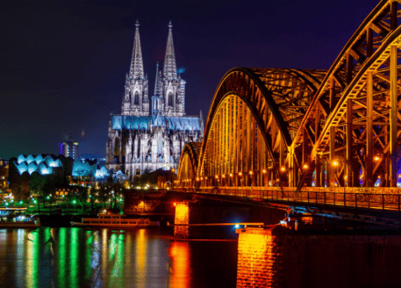 Beliebte Shops in der Kölner Innenstadt in Abendstimmung mit Dom und Hohenzollernbrücke