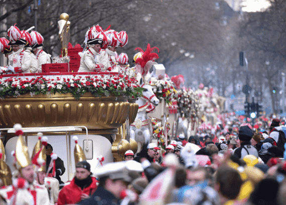 Kölner Rosenmontagszug mit Karnevalswagen und Zuschauern in der Innenstadt